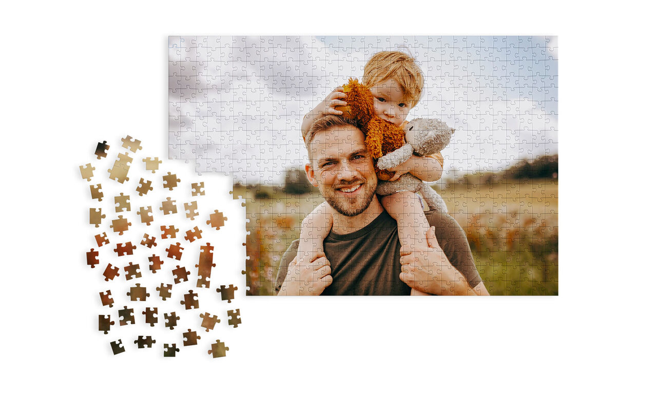 Een puzzel toont een vader met zijn kind op de arm, omgeven door een schilderachtig landschap.