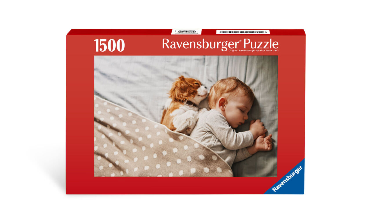 Een nieuwsgierige kitten nestelt zich tegen een slapend kind aan op een gezellige deken.