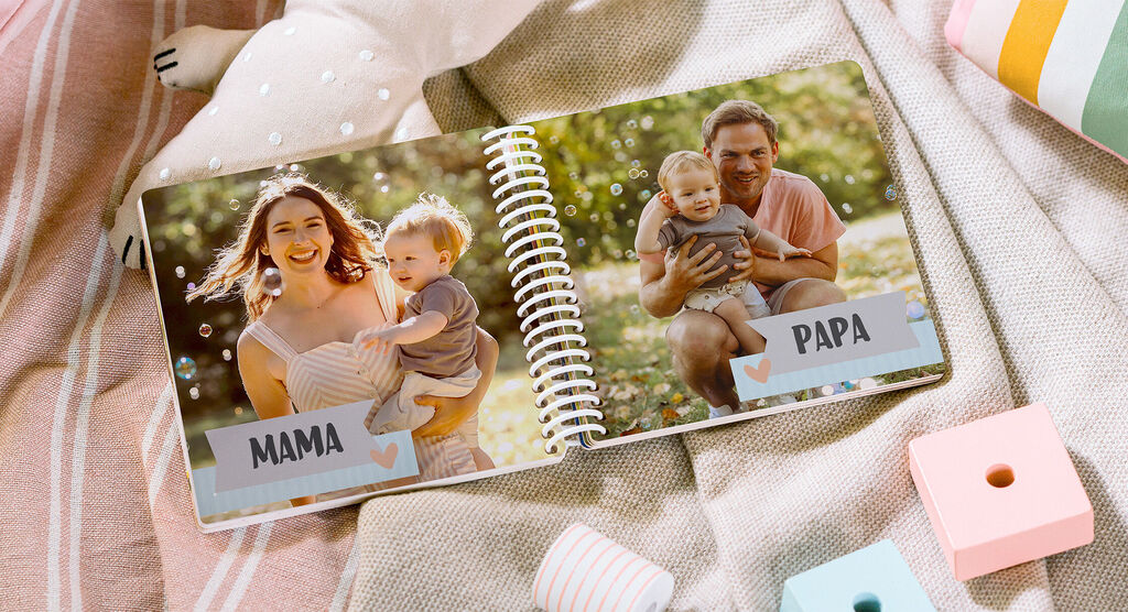 L'image montre un album photo ouvert avec une scène familiale affectueuse. À gauche, une mère avec son enfant; à droite, un père tient aussi son enfant dans un cadre vert et ensoleillé.