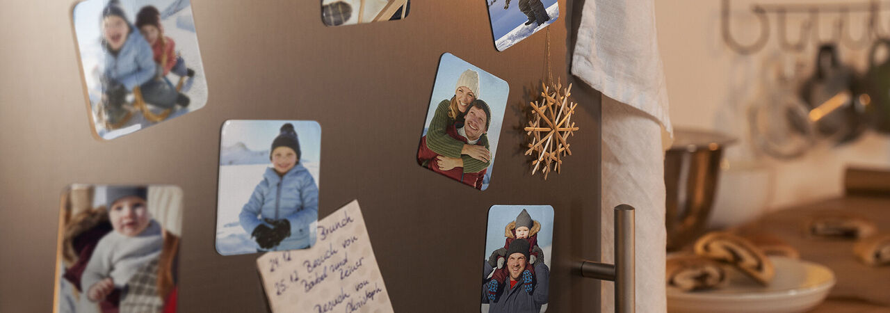 Un frigo avec des photos souvenirs et déco de Noël.