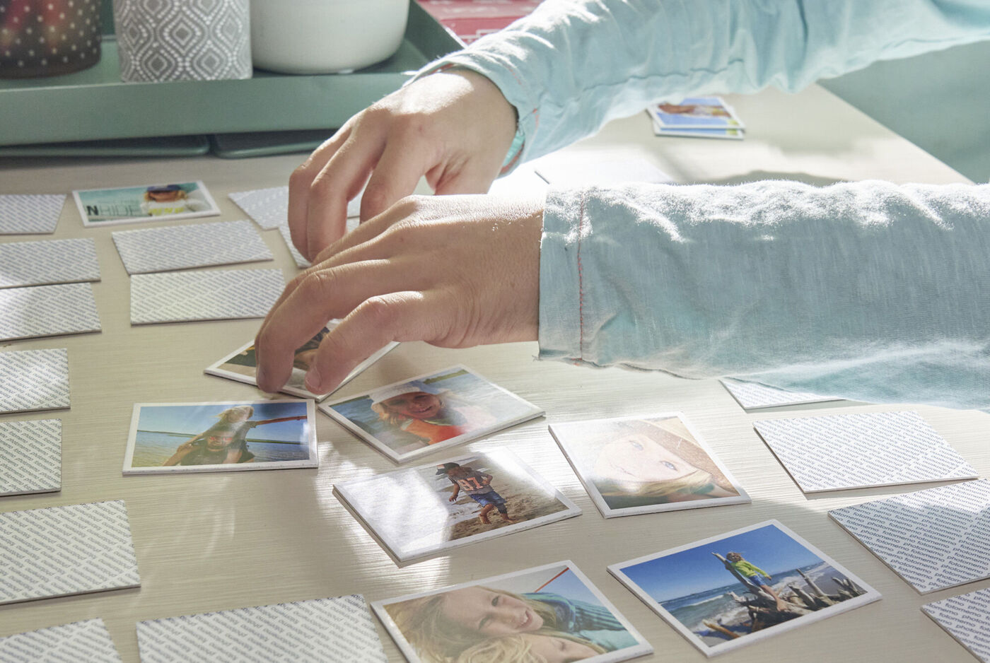 Une personne place des photos sur une table pour créer des souvenirs.