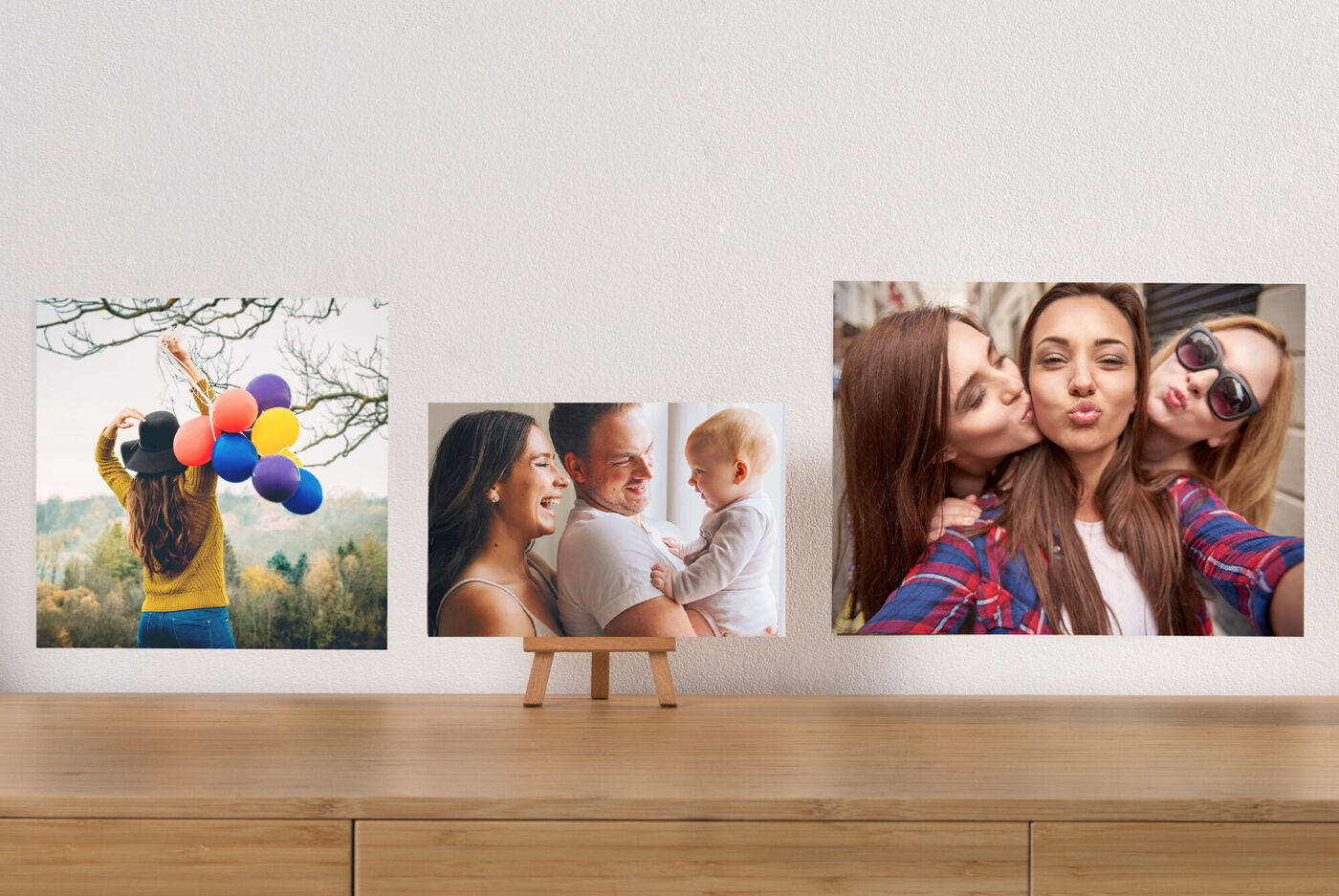 Une personne avec des ballons colorés devant un paysage ; table avec photos variées.